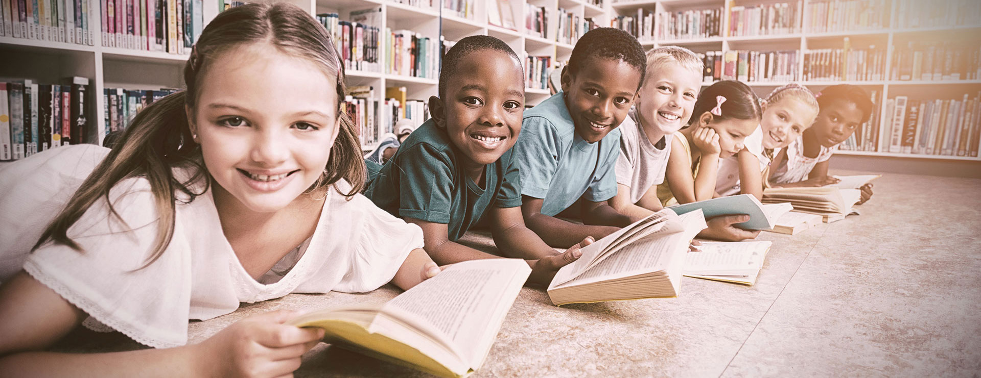 image of a child reading in the library 