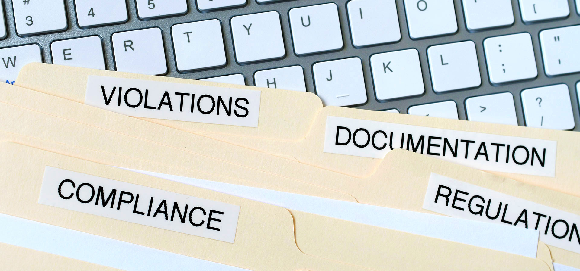 image of compliance folders on a keyboard