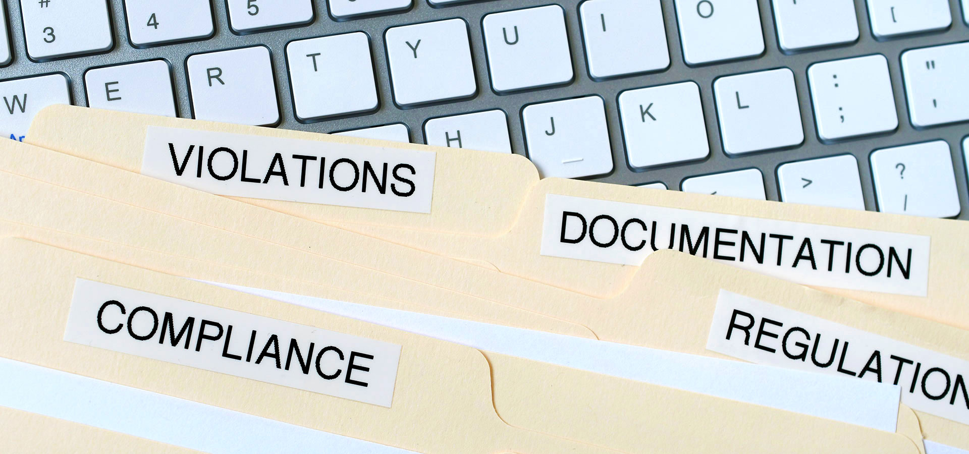  image of compliance folders on a keyboard