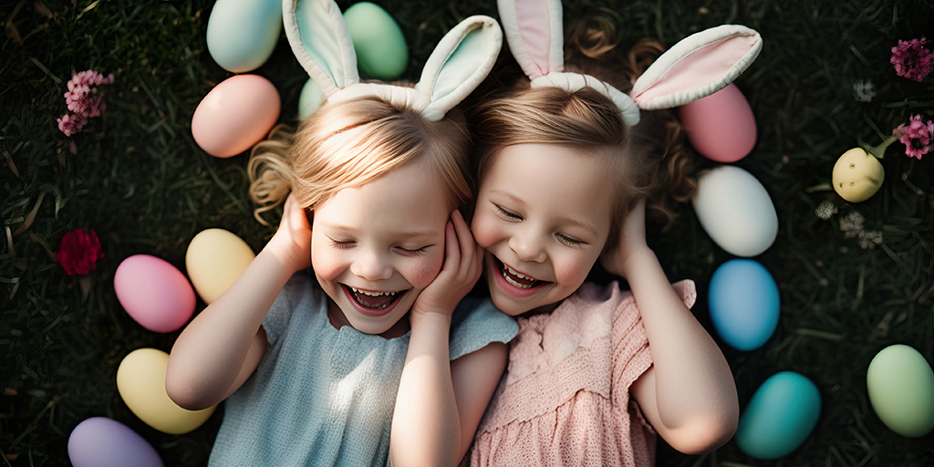 two cute little girls laying in a field with Easter eggs