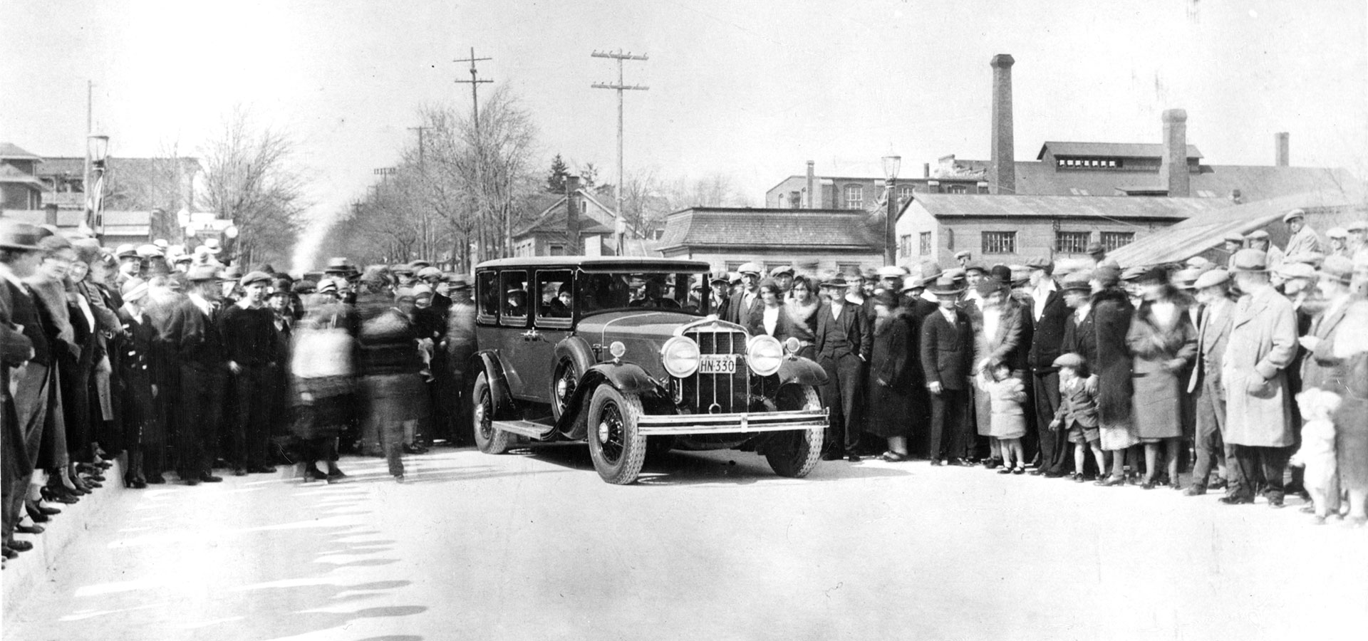 archive image of people in Welland on a street with a car